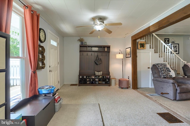 living room featuring carpet floors, stairs, ceiling fan, and visible vents