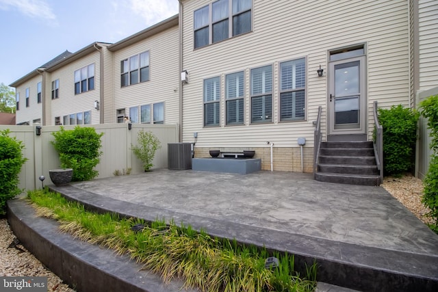 back of property featuring fence, a patio area, and central AC