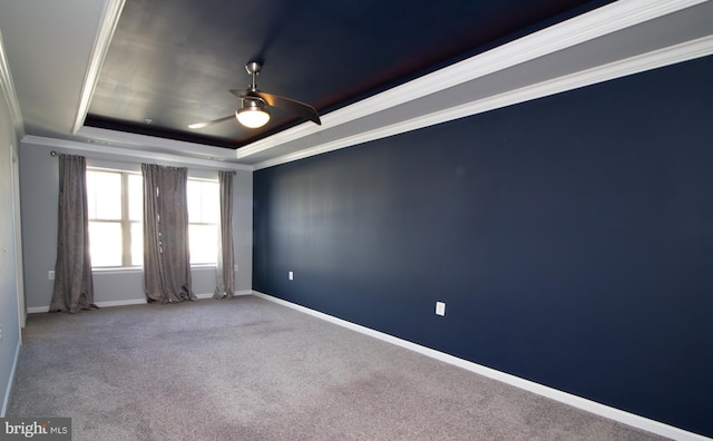 carpeted empty room with baseboards, ornamental molding, a ceiling fan, and a tray ceiling