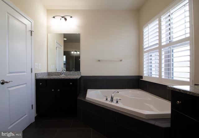 bathroom featuring a garden tub, a shower stall, tile patterned floors, and vanity