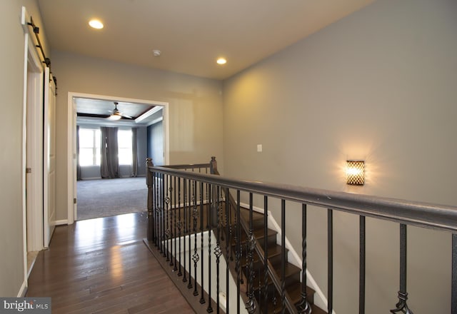 hall featuring recessed lighting, an upstairs landing, and wood finished floors