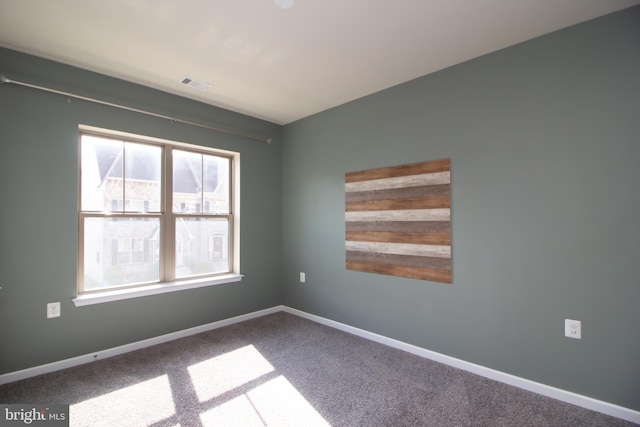 carpeted empty room featuring visible vents and baseboards