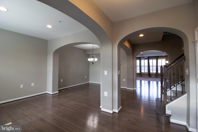 empty room featuring recessed lighting, baseboards, dark wood-style flooring, and stairs