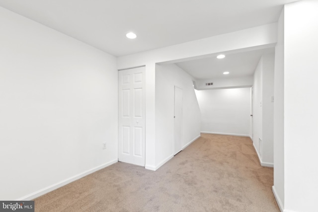 below grade area with light carpet, recessed lighting, and baseboards