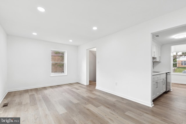 empty room featuring light wood-style flooring, baseboards, and recessed lighting