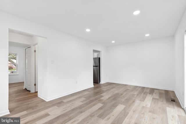 unfurnished room featuring light wood-style floors, recessed lighting, and baseboards
