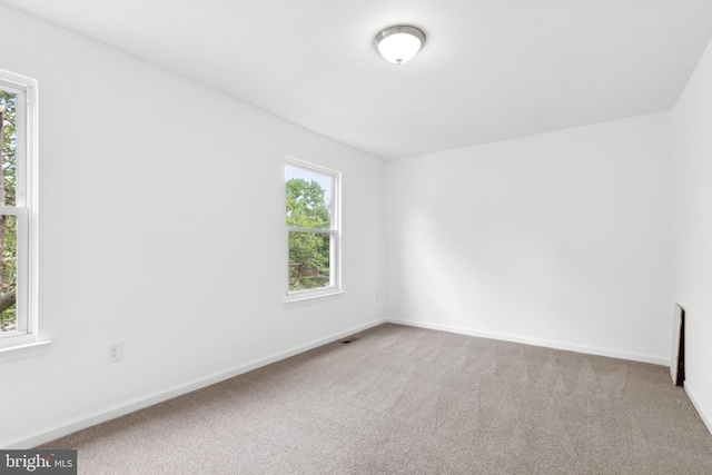 spare room with carpet and baseboards
