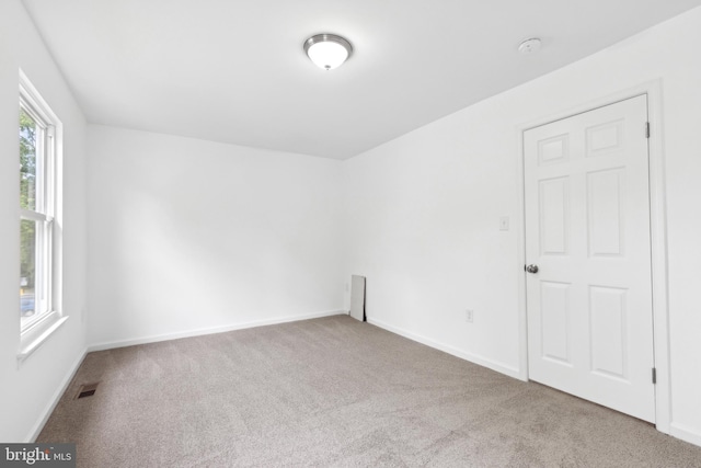 unfurnished room featuring carpet, a smoke detector, and baseboards