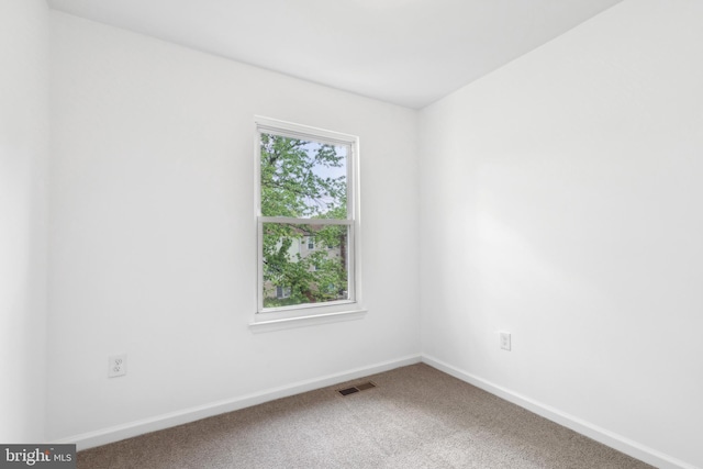 spare room with carpet and baseboards