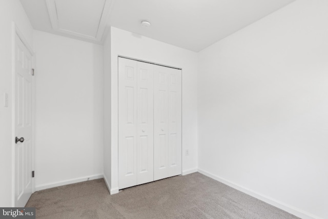 unfurnished bedroom with carpet floors, baseboards, and a closet