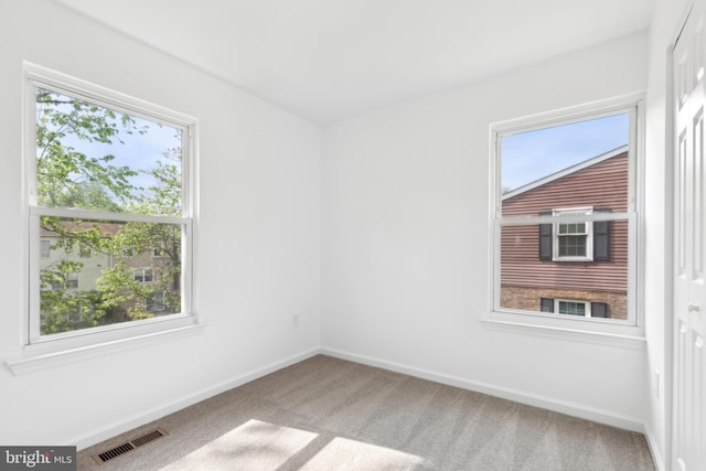 carpeted empty room with baseboards