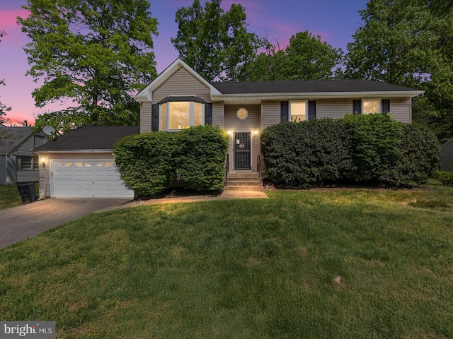 view of front of property featuring entry steps, an attached garage, a front lawn, and aphalt driveway