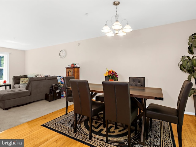 dining room with light wood-style floors and a chandelier