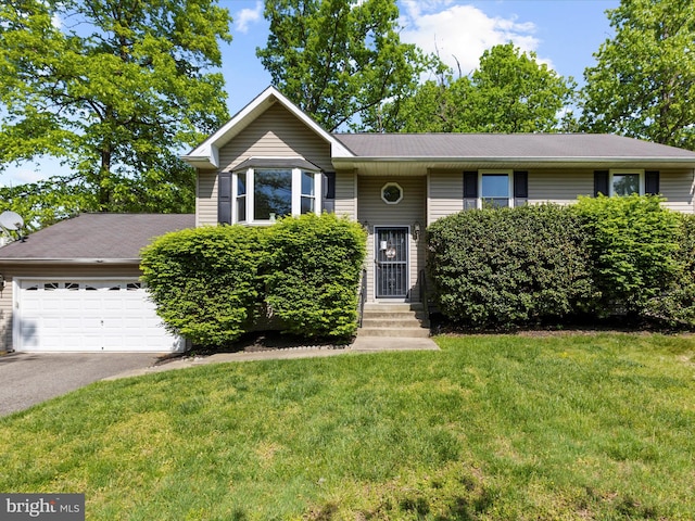 split foyer home featuring an attached garage, driveway, and a front yard