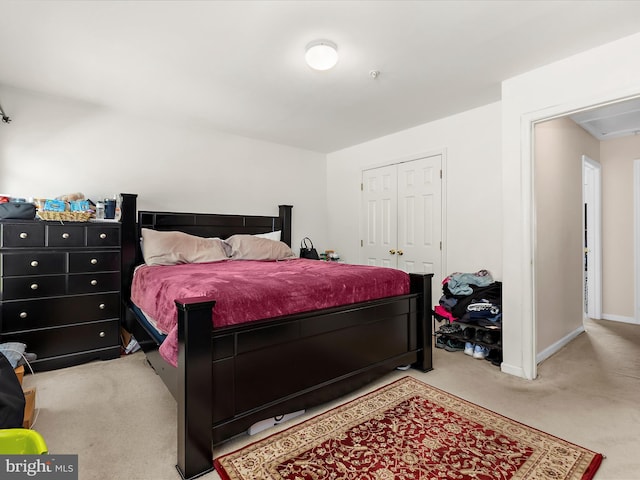 bedroom featuring carpet floors, baseboards, attic access, and a closet