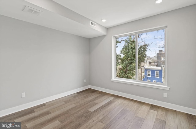 unfurnished room with recessed lighting, baseboards, visible vents, and wood finished floors