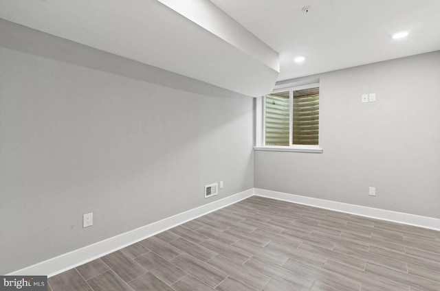below grade area with visible vents, recessed lighting, baseboards, and wood finished floors
