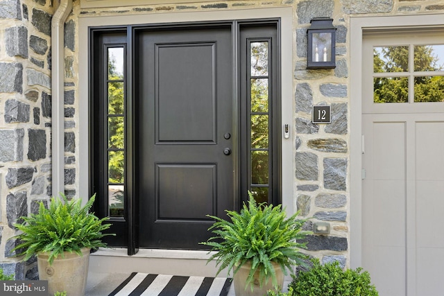 property entrance featuring stone siding
