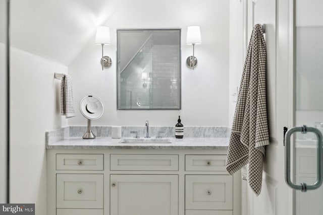 full bath with a shower with shower door, lofted ceiling, and vanity