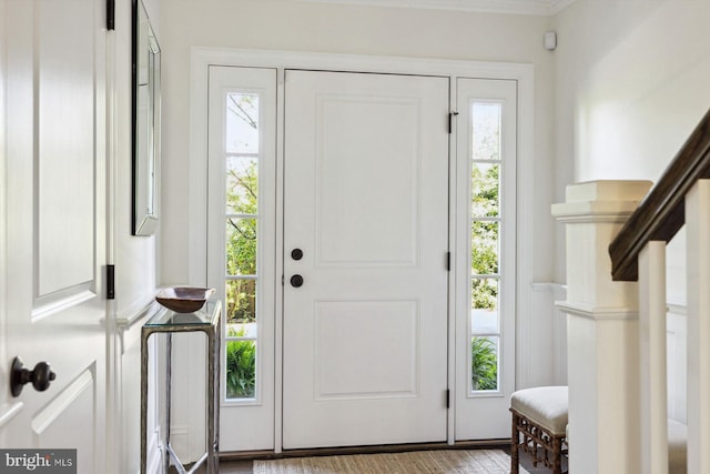 foyer entrance featuring crown molding and a wealth of natural light