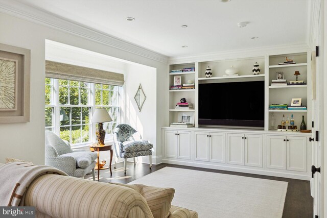 living area featuring crown molding, built in features, and wood finished floors
