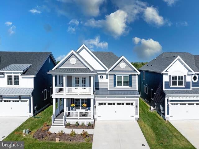 view of front facade featuring covered porch, a standing seam roof, a front lawn, concrete driveway, and an attached garage