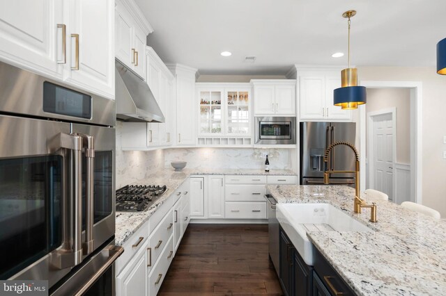 kitchen with appliances with stainless steel finishes, backsplash, white cabinets, and dark wood-style floors