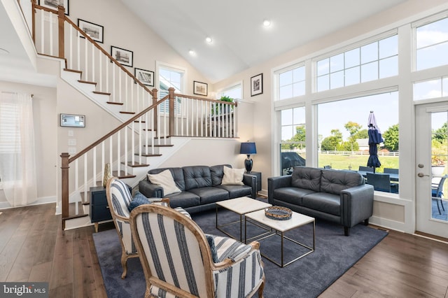 living room with dark wood-style flooring, high vaulted ceiling, plenty of natural light, and stairway