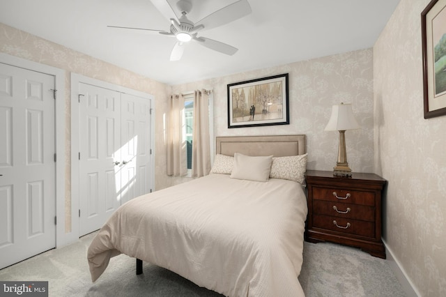 carpeted bedroom with baseboards, a ceiling fan, a closet, and wallpapered walls