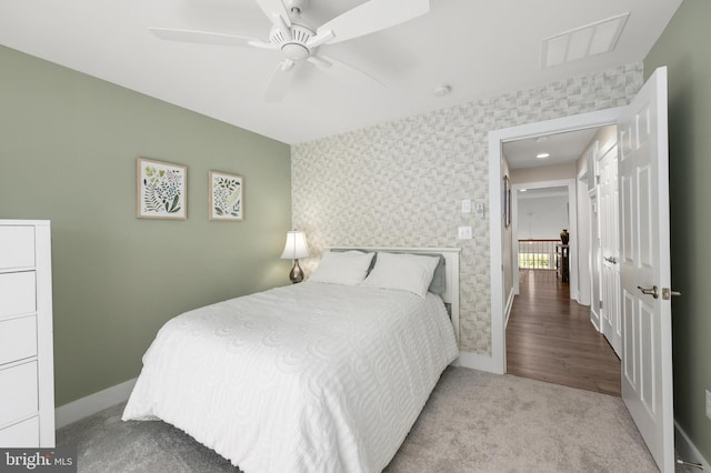 carpeted bedroom featuring baseboards, visible vents, and ceiling fan