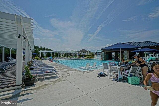 community pool featuring a pergola and a patio area