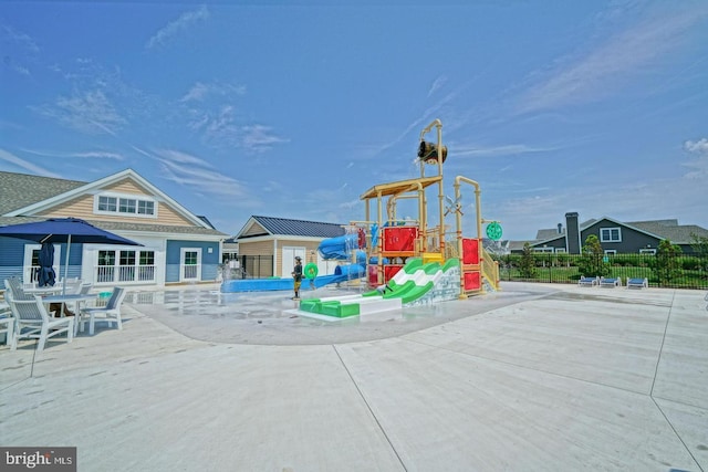 community jungle gym featuring fence and a patio area
