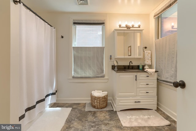 bathroom with baseboards, a shower with shower curtain, vanity, and visible vents