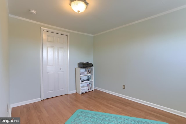 unfurnished bedroom with crown molding, baseboards, a closet, and wood finished floors