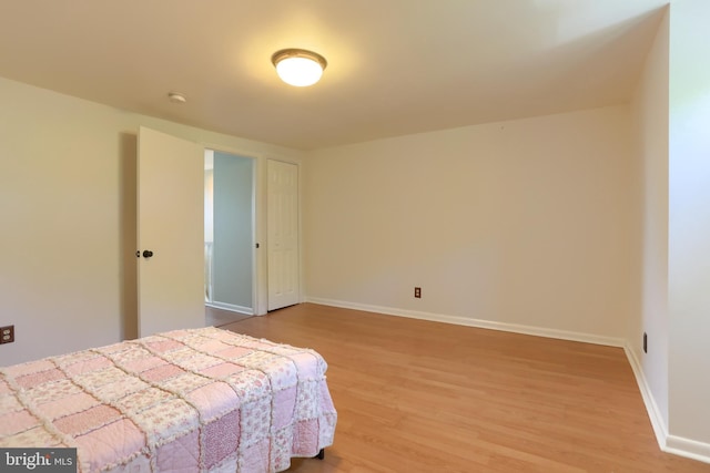 bedroom featuring baseboards and wood finished floors