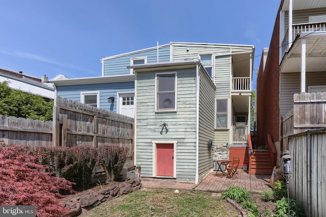 rear view of house featuring a patio and fence