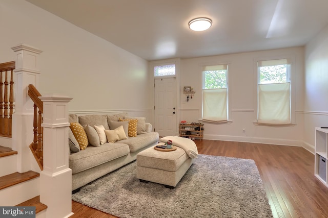 living area with stairway, baseboards, and light wood-style flooring
