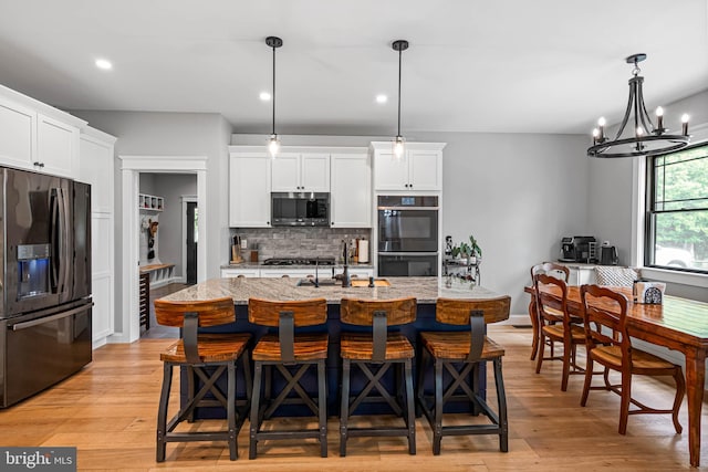32991 Daisey Rd, Frankford, DE 19945 - kitchen with a sink, light wood finished floors, backsplash, and black appliances
