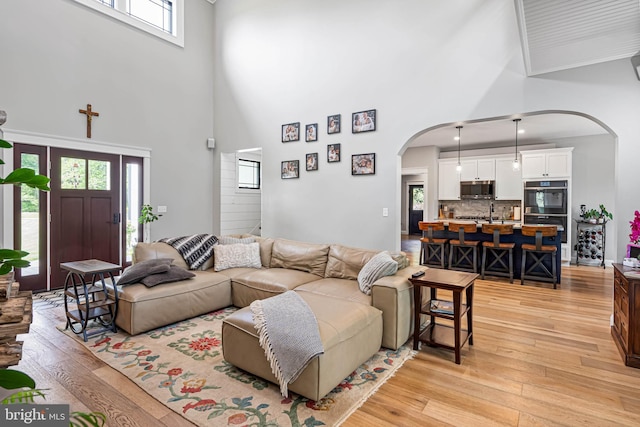 32991 Daisey Rd, Frankford, DE 19945 - living area featuring arched walkways, light wood-style floors, and a towering ceiling