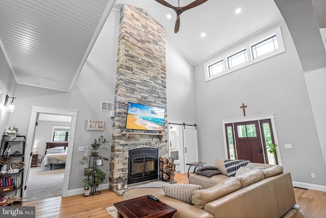 32991 Daisey Rd, Frankford, DE 19945 - living area featuring ceiling fan, high vaulted ceiling, a stone fireplace, light wood-style flooring, and visible vents