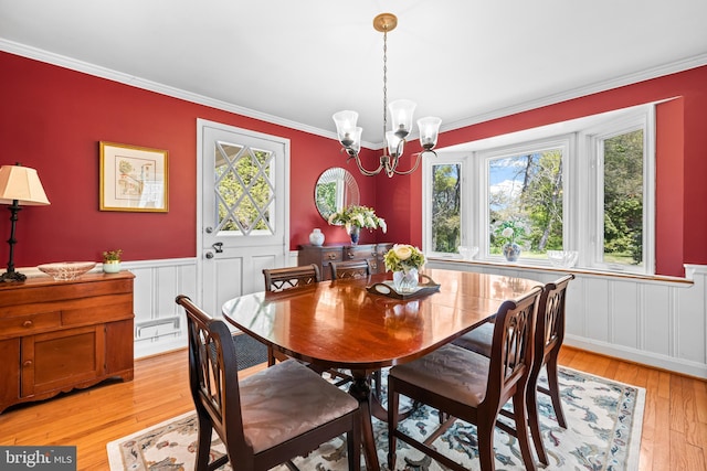 2430 Stanwick Rd, Phoenix, MD 21131 - dining room with crown molding, a decorative wall, a wainscoted wall, light wood finished floors, and a notable chandelier
