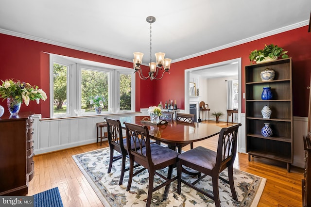 2430 Stanwick Rd, Phoenix, MD 21131 - dining space with wainscoting, a notable chandelier, ornamental molding, and light wood-style flooring