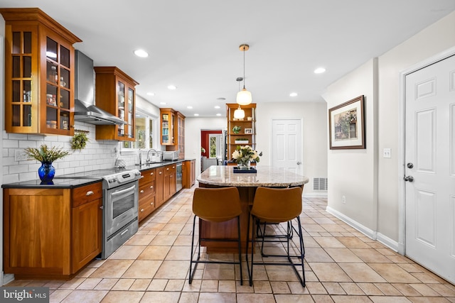 2430 Stanwick Rd, Phoenix, MD 21131 - kitchen with brown cabinetry, a kitchen island, appliances with stainless steel finishes, a sink, and wall chimney exhaust hood
