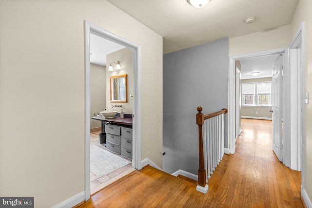 2430 Stanwick Rd, Phoenix, MD 21131 - corridor with baseboards, an upstairs landing, a sink, and light wood-style floors