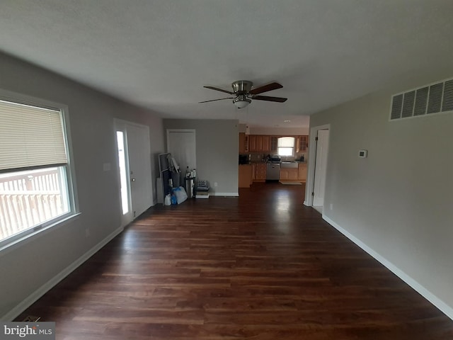 unfurnished living room with visible vents, dark wood-style flooring, ceiling fan, and baseboards
