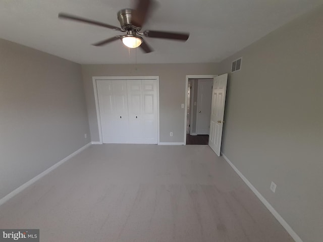 unfurnished bedroom featuring carpet floors, baseboards, visible vents, and a closet