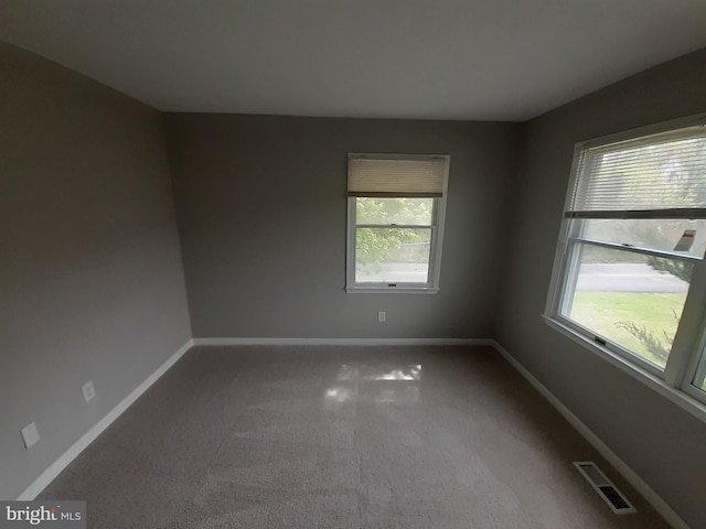 carpeted spare room with baseboards and visible vents