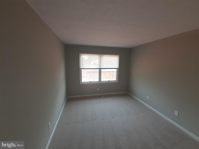 carpeted empty room with baseboards and visible vents