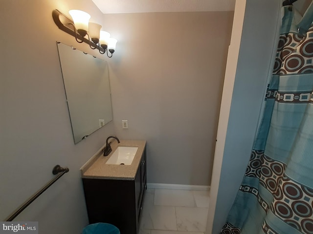 bathroom featuring vanity, baseboards, and marble finish floor