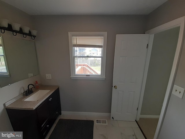 bathroom with visible vents, a wealth of natural light, marble finish floor, and vanity